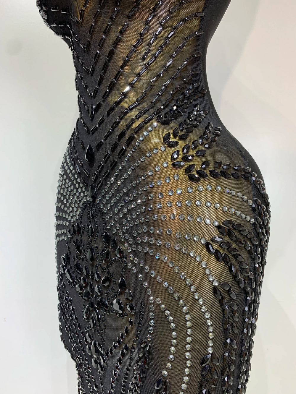 Black dress with intricate beadwork on a white background