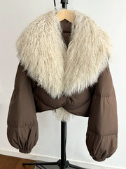 Brown cropped puffer jacket with a large curly textured fur collar and full sleeves.