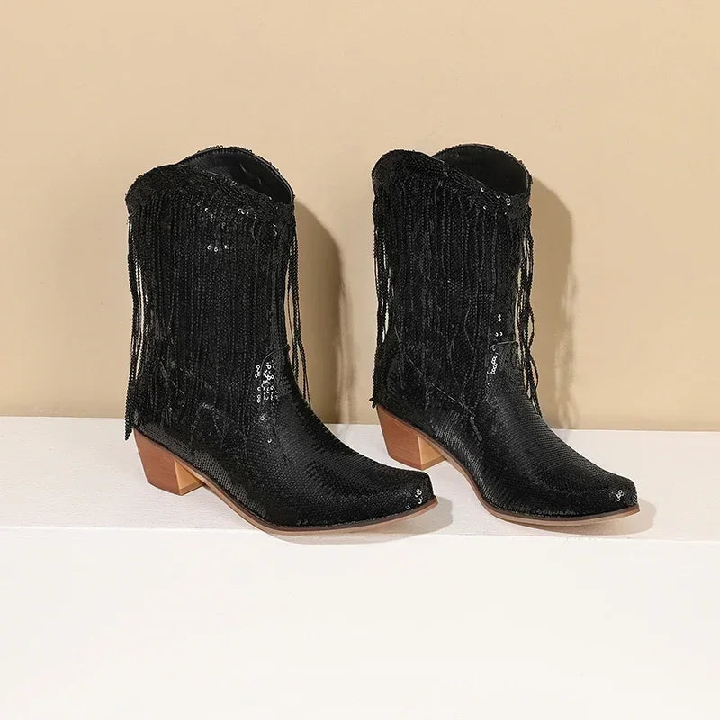 Pair of black fringed boots on a beige background