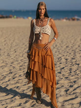 Woman in a layered skirt and bra top on a beach
