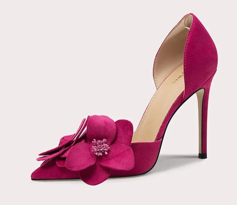 Pink high-heeled shoe with floral design on a light gray background