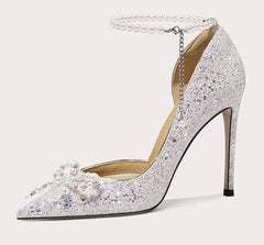 Sparkling high-heeled shoe with pearl details on a light gray background