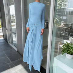 Person wearing a light blue dress standing in front of a glass door.