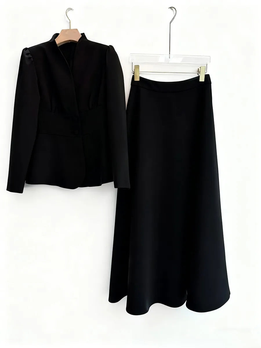 Black outfit with jacket and skirt on hangers against a white background