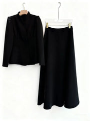 Black outfit with jacket and skirt on hangers against a white background