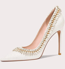 White high-heeled shoe with pearl embellishments on a white background
