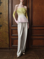 Model wearing pleated peplum strapless top with trousers