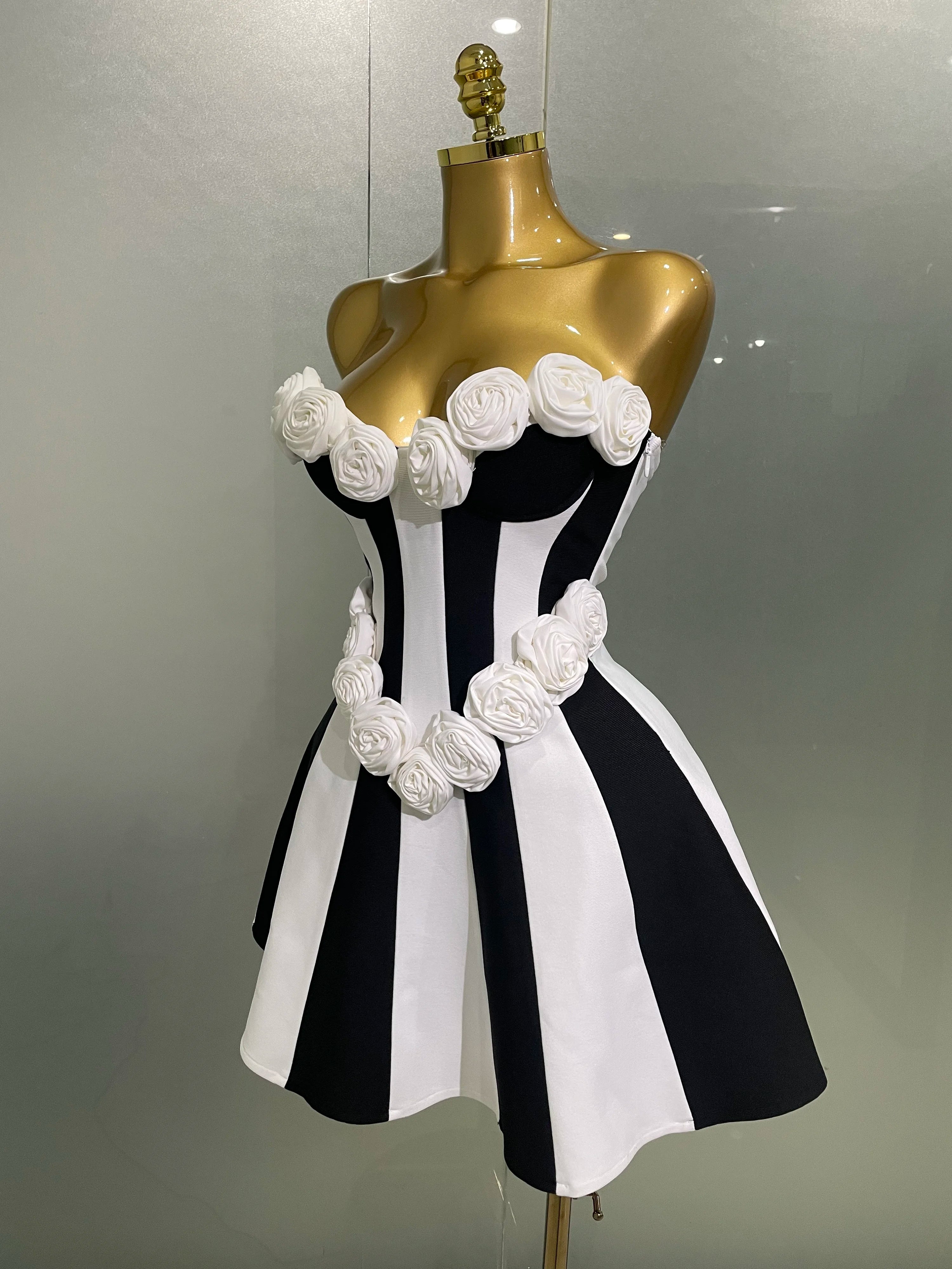 Black and white striped dress with floral details on a mannequin against a neutral background