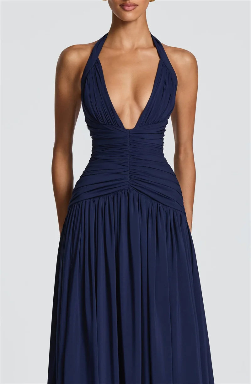 Navy blue halter neck gown on a plain background