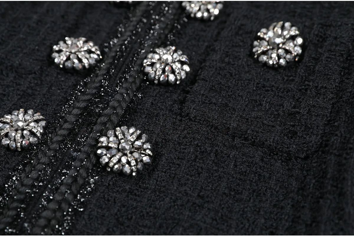 Close-up of black fabric with silver embellishments on a dark background