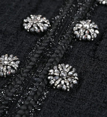 Close-up of black fabric with silver embellishments on a dark background