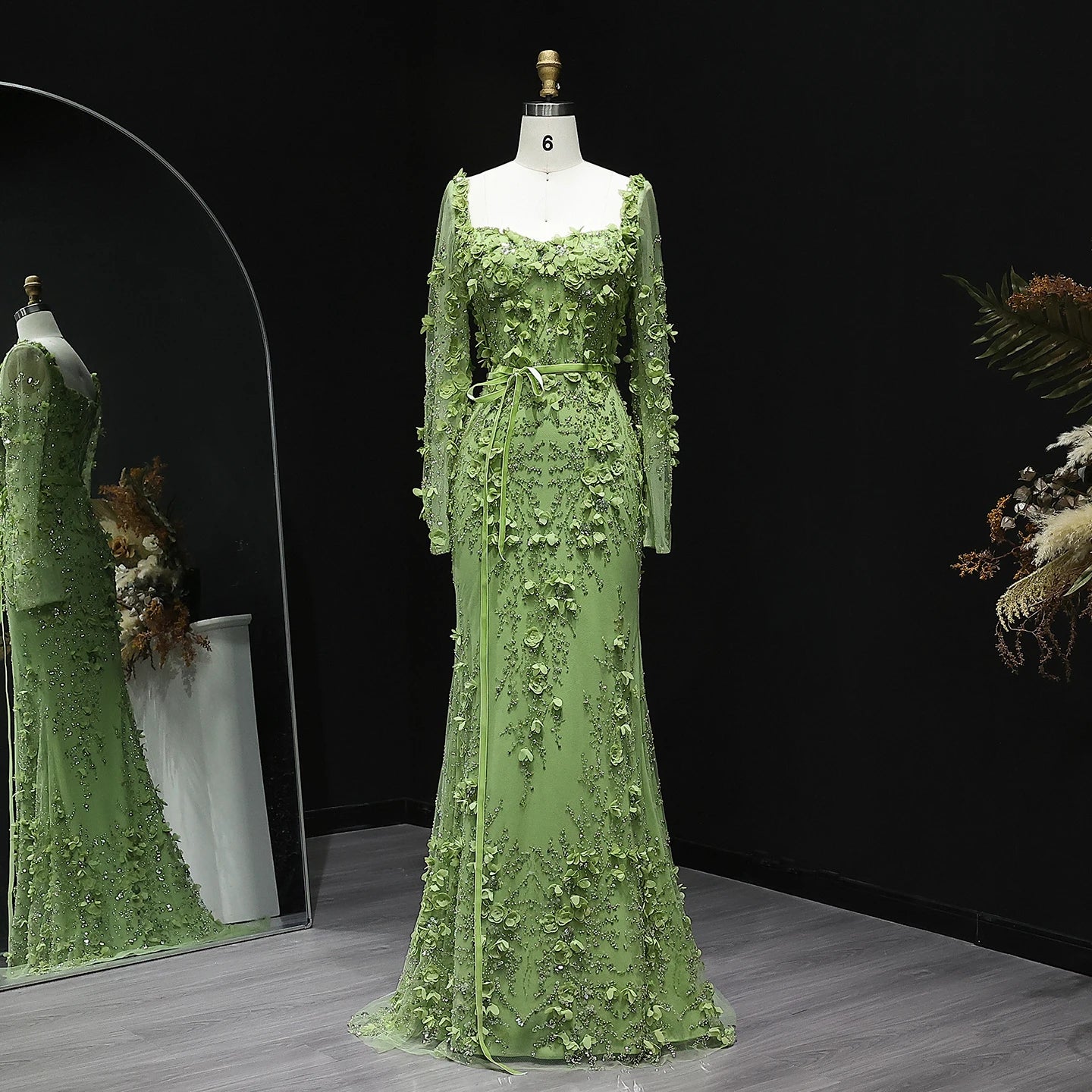Green lace dress on a mannequin against a dark background
