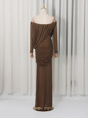 Brown off-shoulder evening gown on a mannequin against a white curtain background