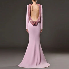 Pink evening gown with open back and floral detail on a dark background