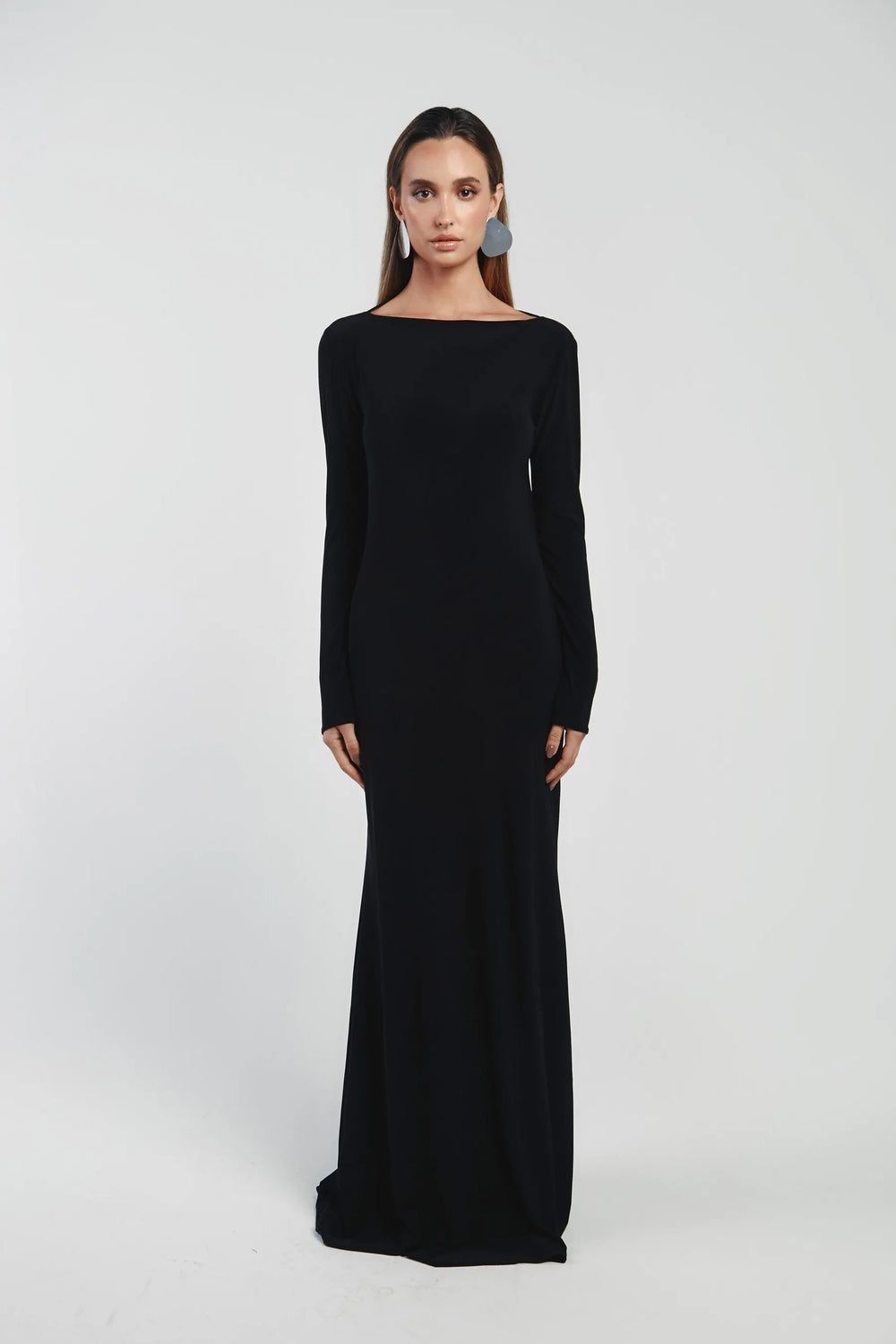 Woman wearing a black long-sleeve gown on a white background