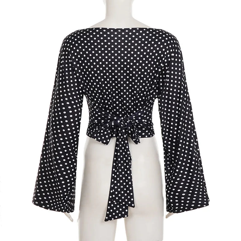 Black polka dot blouse on a mannequin with a white background