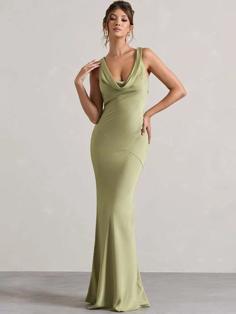 Woman wearing a green evening gown against a plain background