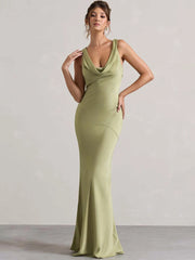 Woman wearing a green evening gown against a plain background