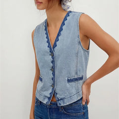 Detail of the embroidered trim on a light wash denim vest.