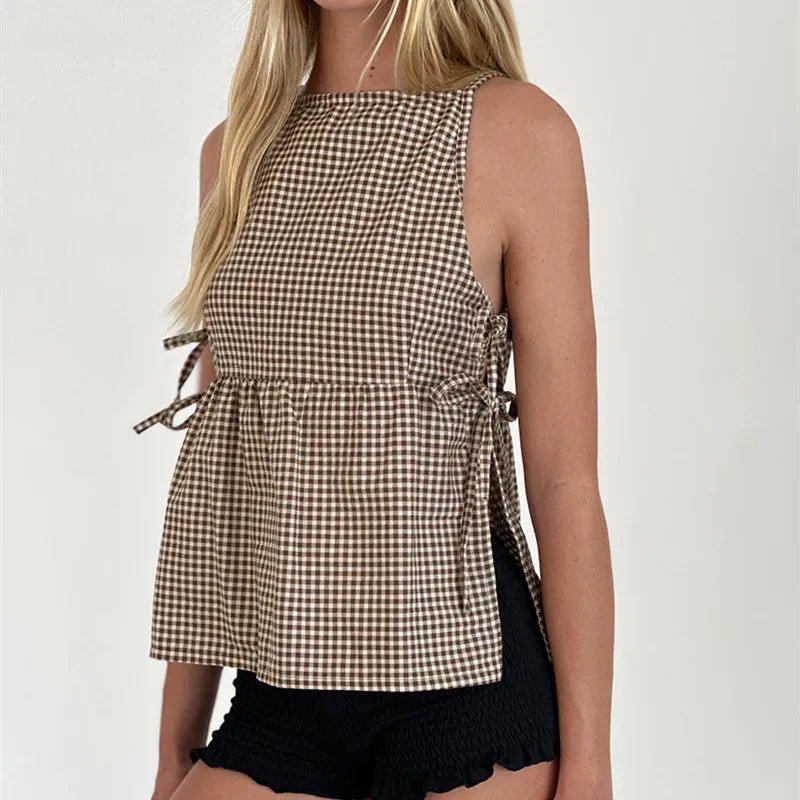 Woman wearing a checkered top with tied sides on a white background