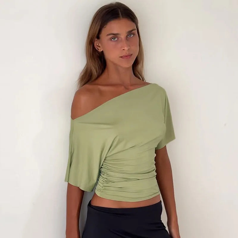 Woman wearing a green off-shoulder top against a white background