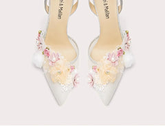 White high-heeled shoes with floral decorations on a white background