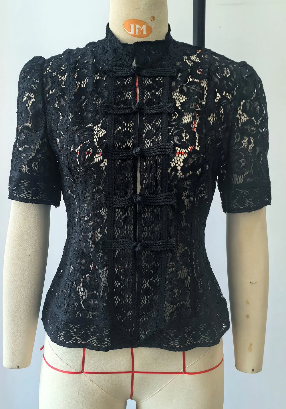 Black lace top on a mannequin with a white background