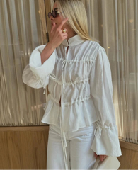 Woman wearing a white outfit with a blurred background
