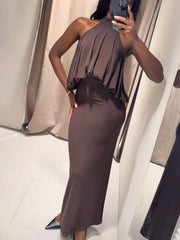 Person wearing a brown one-shoulder dress taking a mirror selfie.