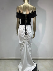 Mannequin wearing a black and white dress with a corset-style top against a plain background