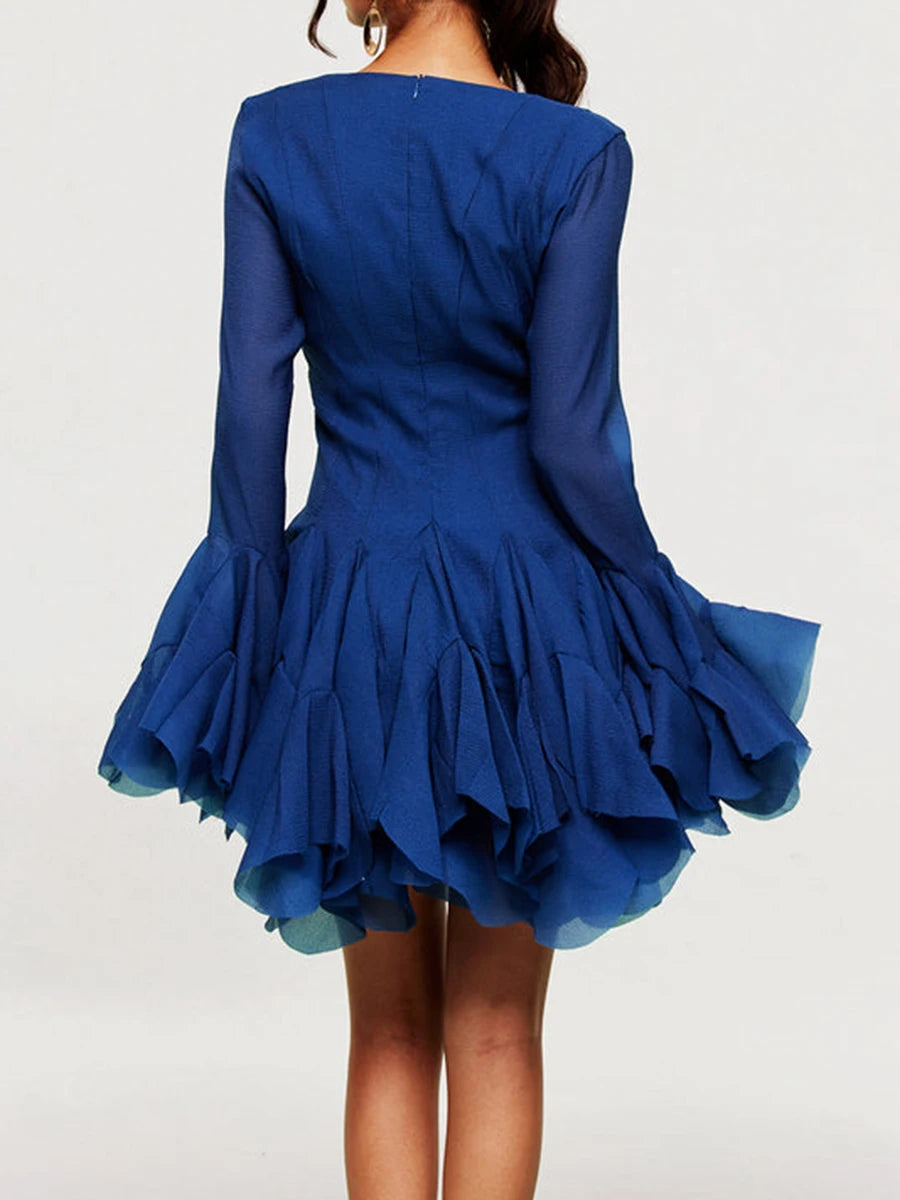 Blue dress with long sleeves and ruffled skirt on a white background