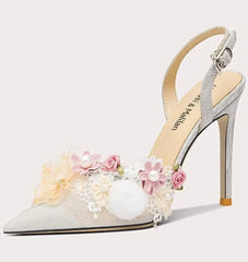 High-heeled shoe with floral decorations on a light gray background