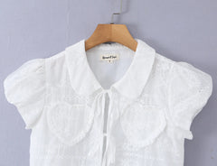 Close-up of collar and chest details on white crop top
