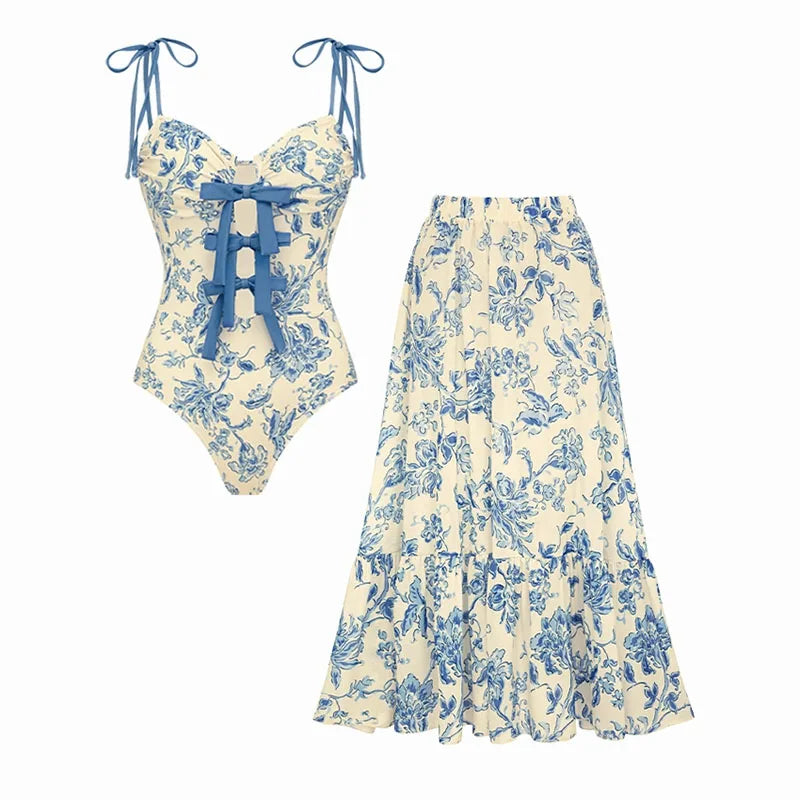 Flat lay of a blue floral print one-piece swimsuit and a matching flowing skirt.