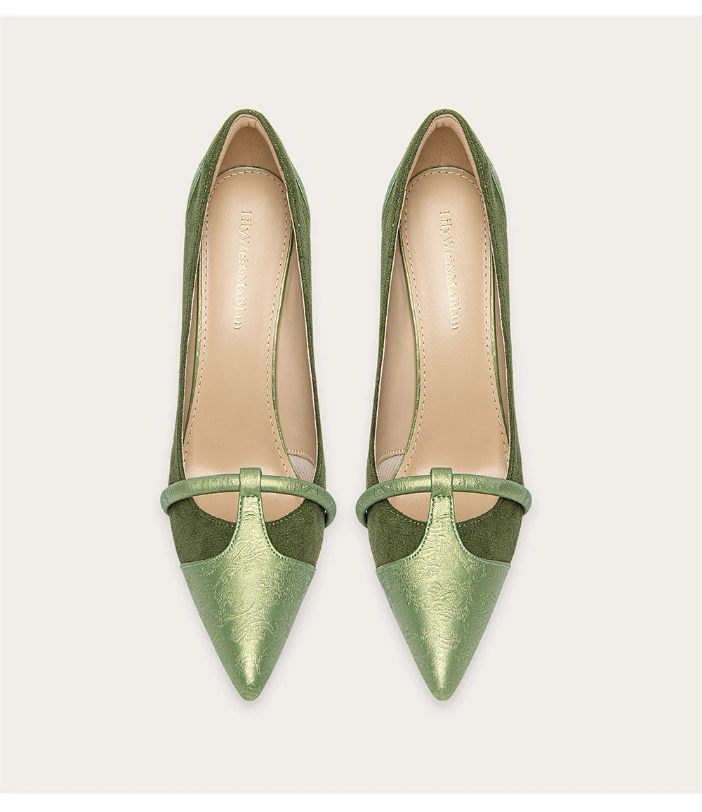 Pair of green pointed-toe high heels on a light gray background