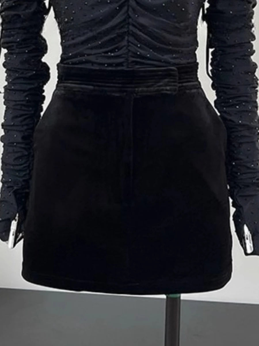 Black textured top and skirt set on a mannequin against a neutral background