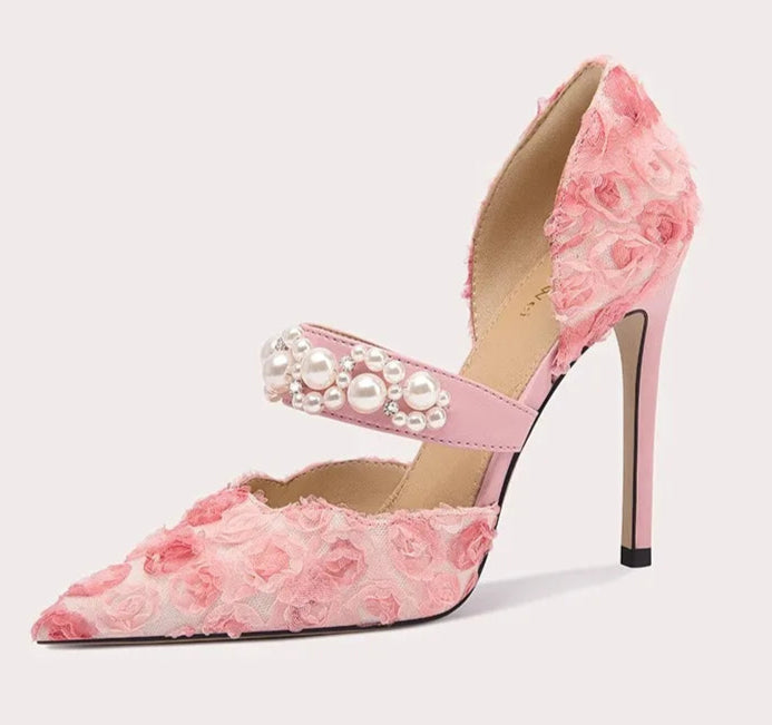 Pink floral high-heeled shoe with pearl details on a light gray background