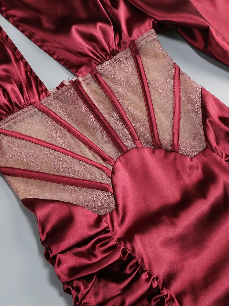 Red satin garment with sheer lace detailing on a light gray background