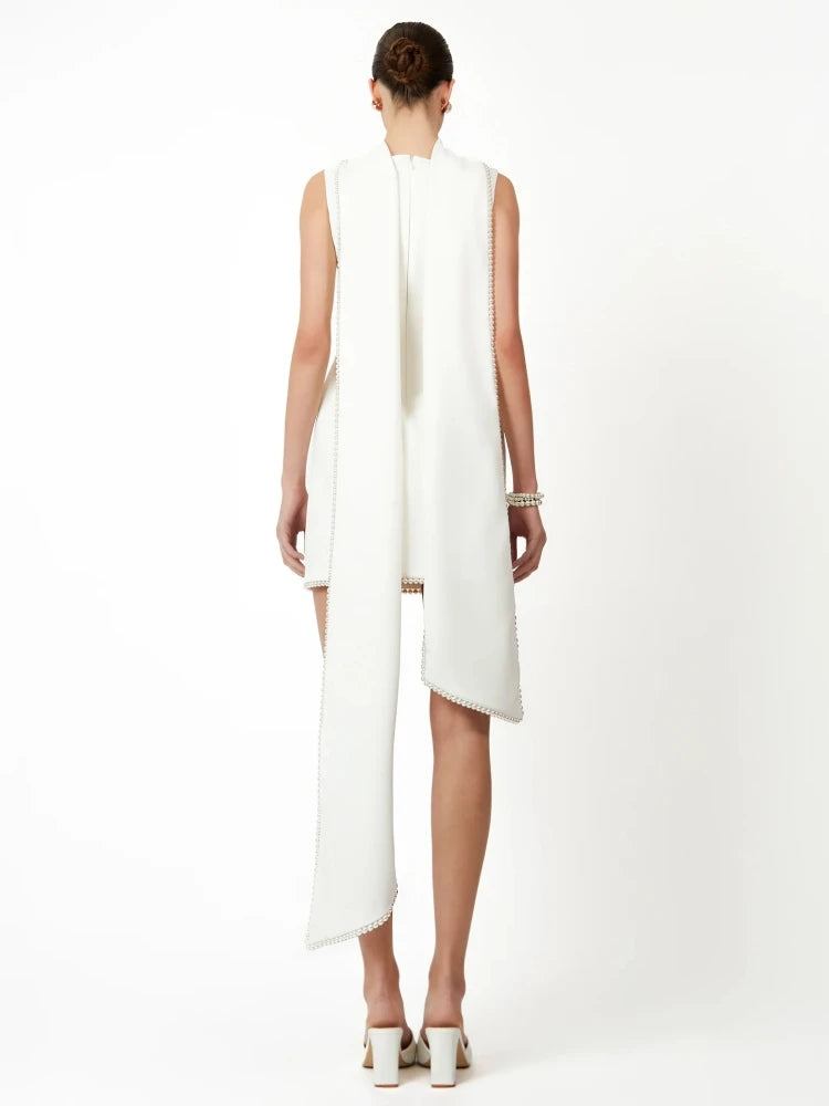 Woman wearing a white sleeveless dress with a slit on a white background