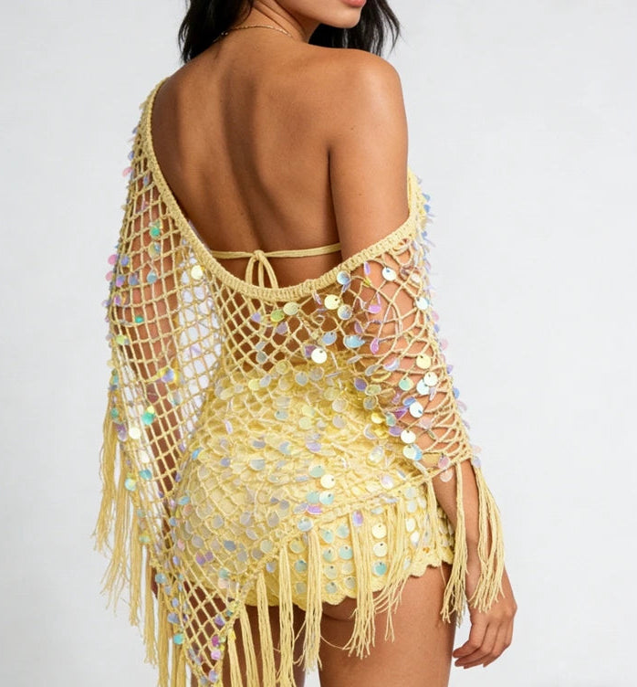 Back view of a yellow sequin knit poncho with fringe hem.