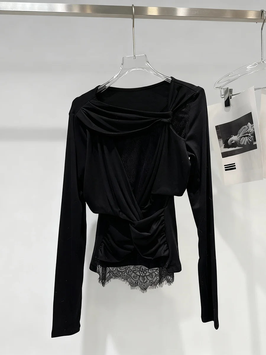 Black long-sleeve top with lace detail on a hanger against a white background