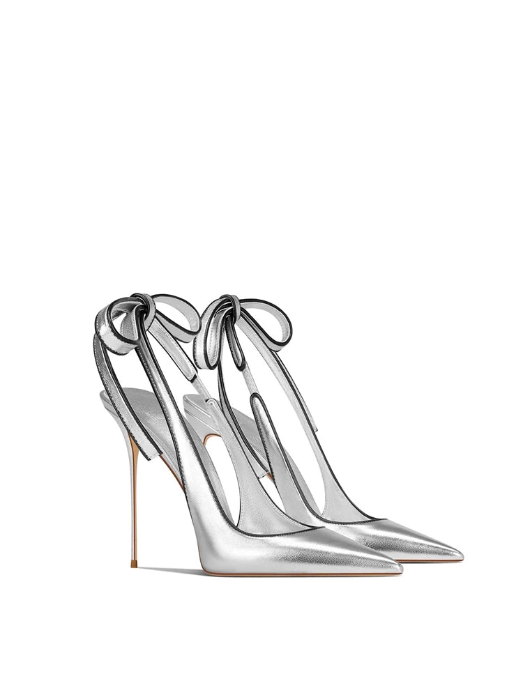Clear high-heeled shoes with ribbon details on a white background