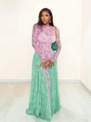 Woman wearing a pink and green dress with a gold clutch against a white background