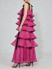 Pink ruffled dress with black trim on a white background