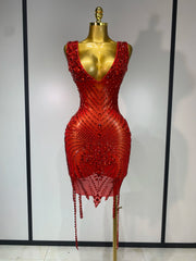 Red beaded dress on a mannequin against a plain background