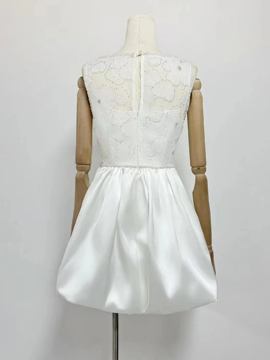 White dress with lace top on a mannequin against a white background