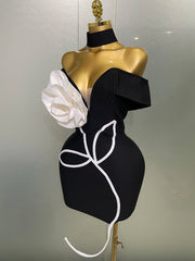 Black dress with white floral design on a mannequin against a plain background