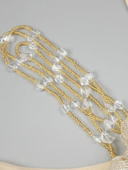 Gold chain with clear beads on a gray background