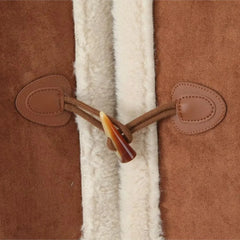 Close-up of a brown leather duffel bag with a white fur lining.