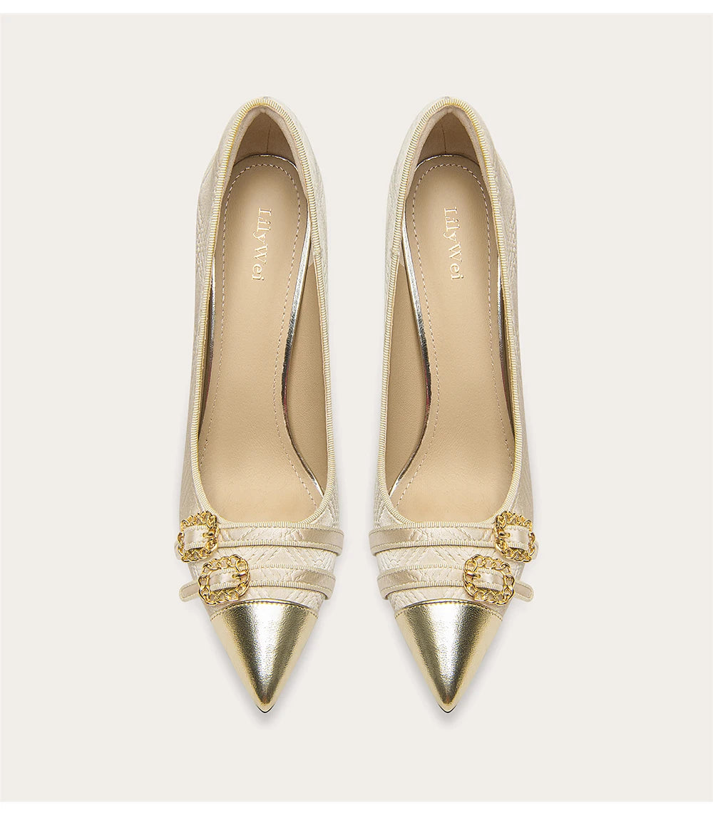 Pair of gold pointed-toe shoes with decorative straps on a white background